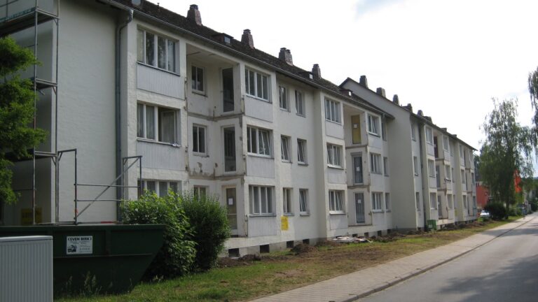 Ein Vorher-Bild eines sanierungsbedürftigen alten Gebäudes in der Gerhart-Hauptmann-Straße 1-11. Die einst weiße Grundierung ist durch die Zeit verfärbt worden.