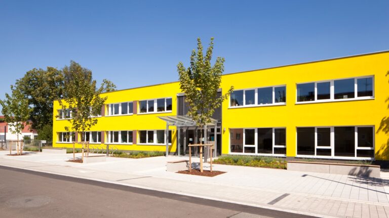 Der Firmensitz der HDWW: Ein modernes Gebäude mit auffallend gelber Fassade und weißen Fenstern.